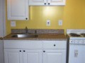 Kitchen with sink, garbage disposal, cabinets and electric stove installed by Pro Home Service and Repair in basement apartment at home on Wisconsin Ave. NW near Washington National Cathedral.